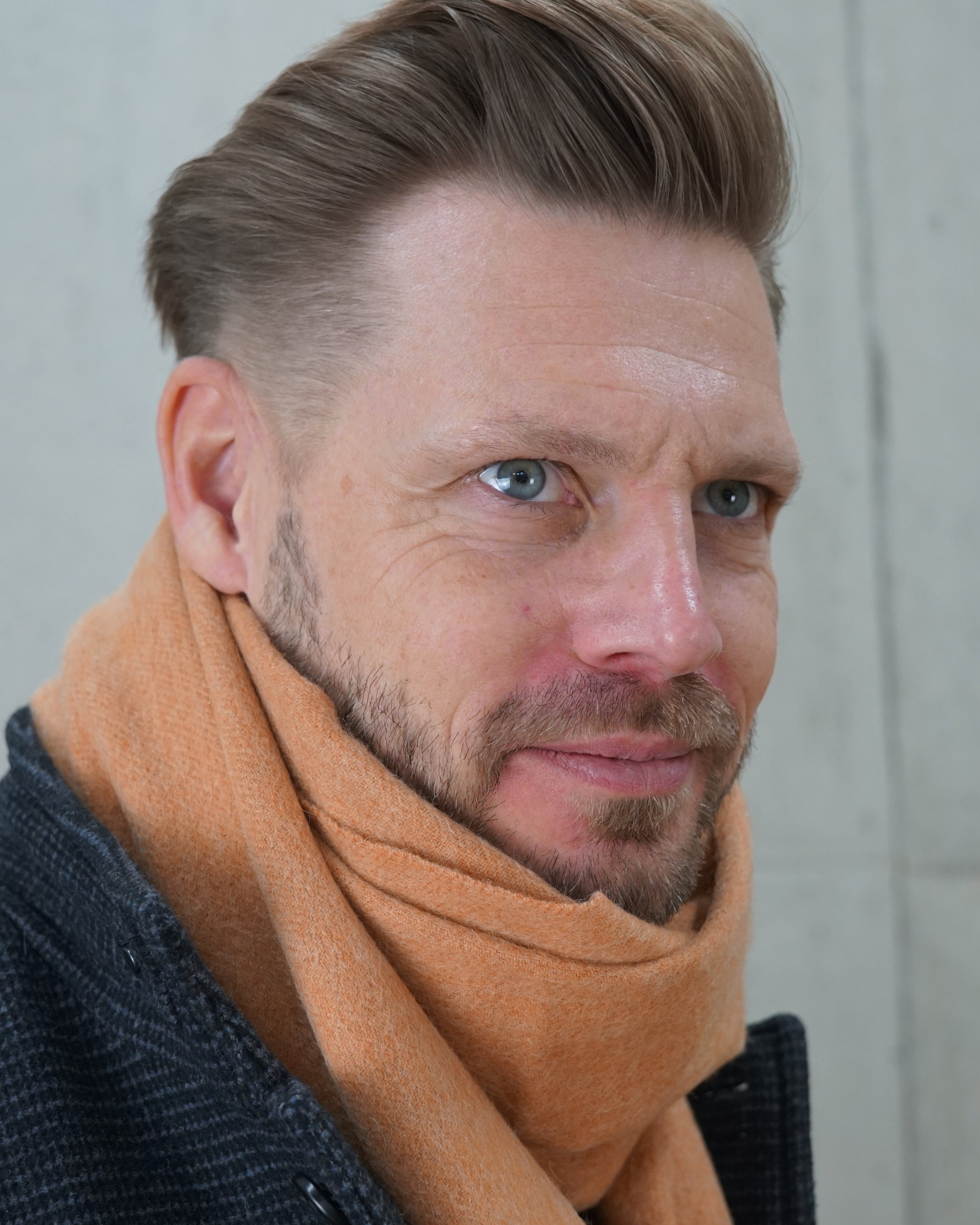 Schal „Caramel Warmth“ aus 100% karamellfarbener Schurwolle Nahaufnahme getragen von einem Mann