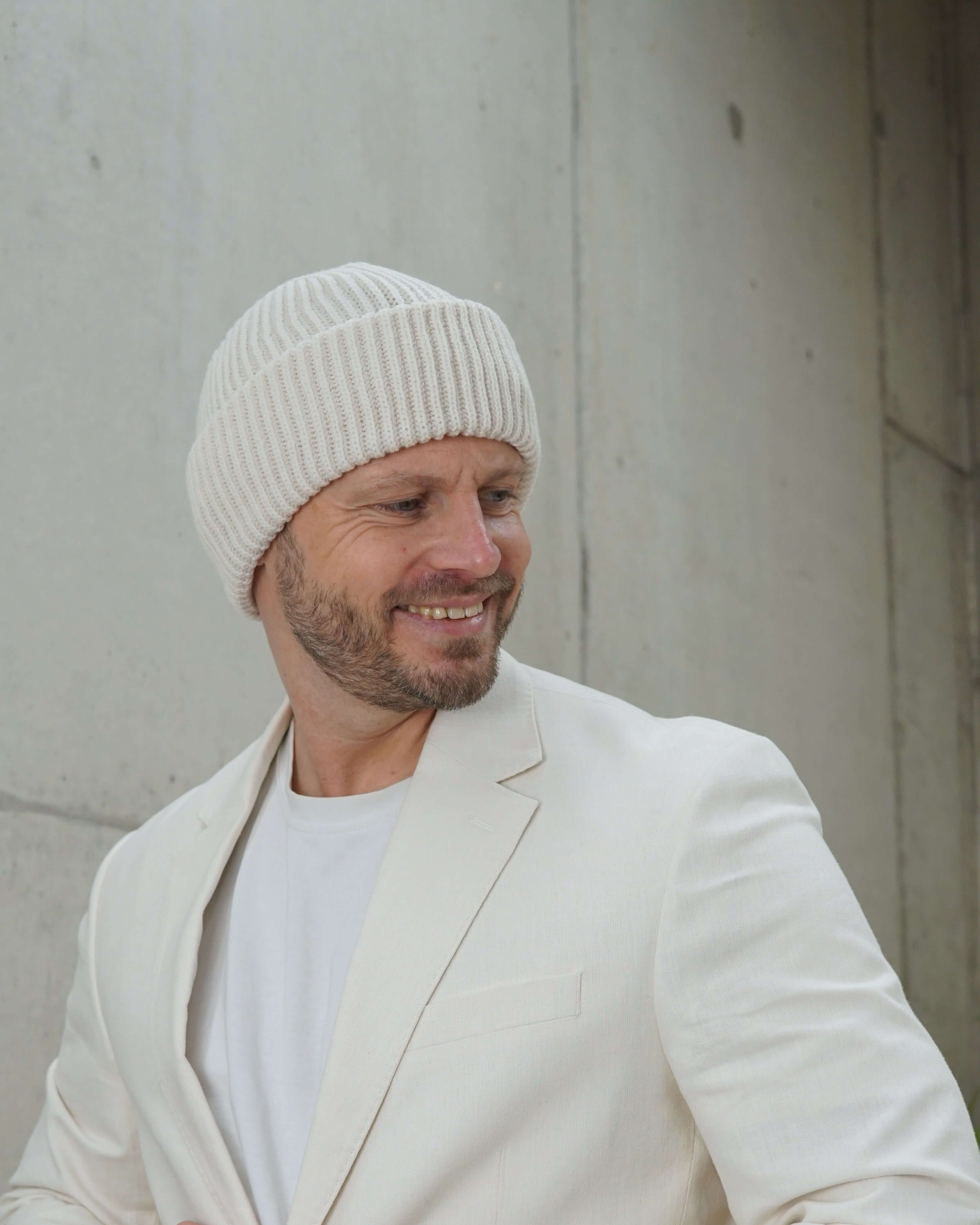 Beanie-Wollmütze schneeweiss getragen von einem lachendem Mann