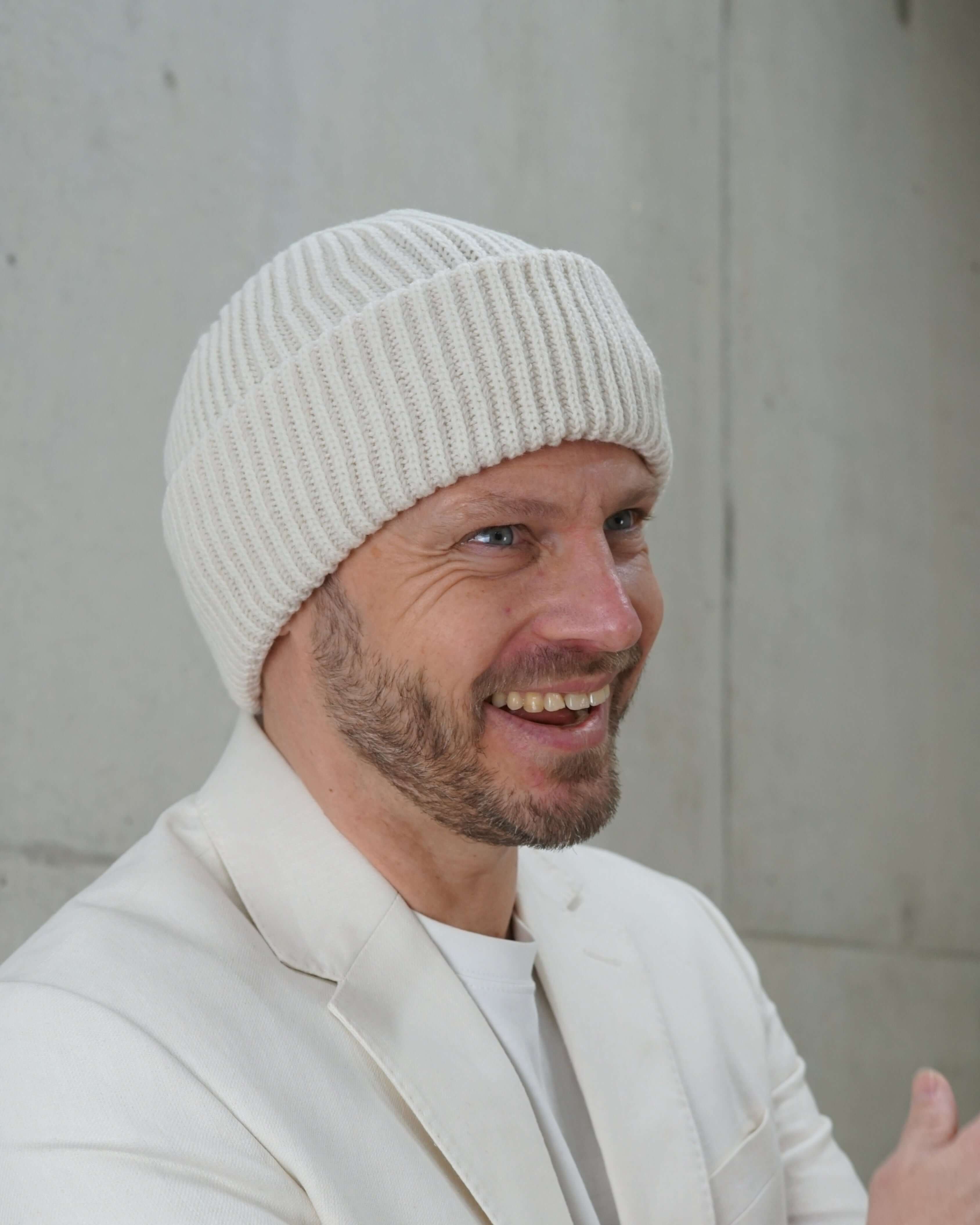 Beanie-Wollmütze schneeweiss getragen von lachendem Mann