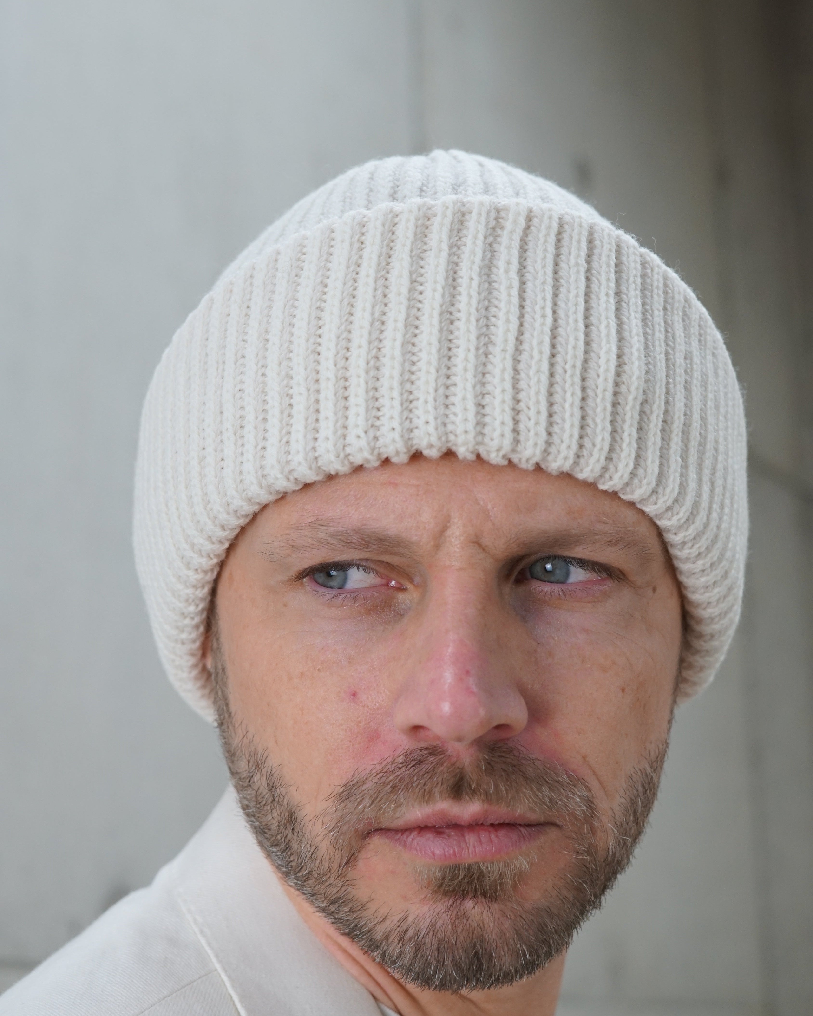 Kopfansicht eines Mannes mit Beanie-Wollmütze schneeweiss front