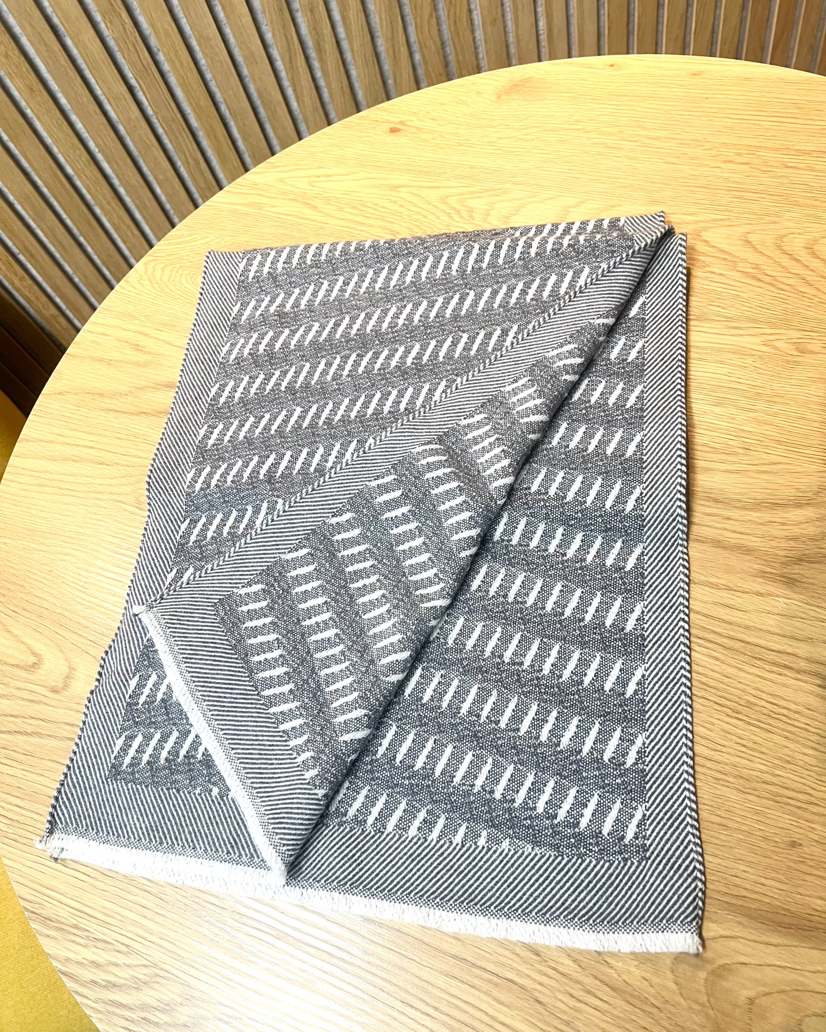 Strukturschal "Soil grey" aus Schurwolle und Kaschmir gelegt auf einem Tisch